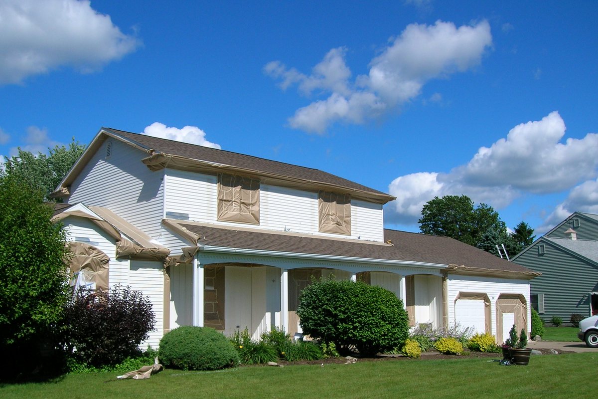 The same Erie colonial mid-refinish, windows masked, old finish still on